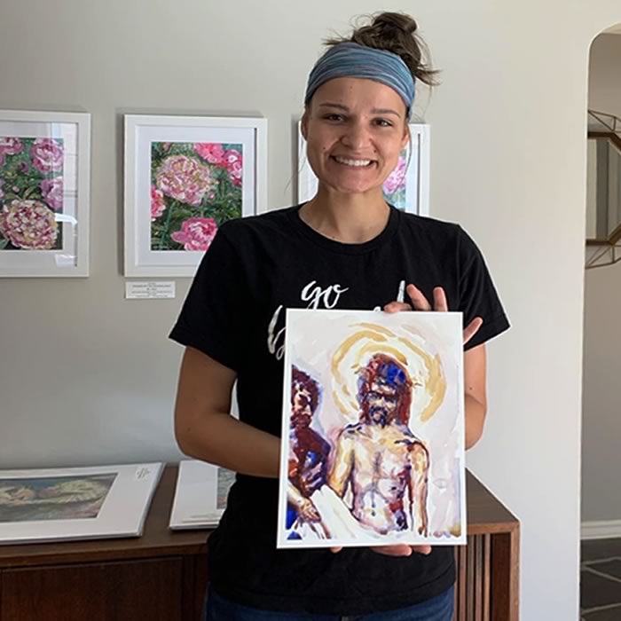 A person holding a painting of Jesus